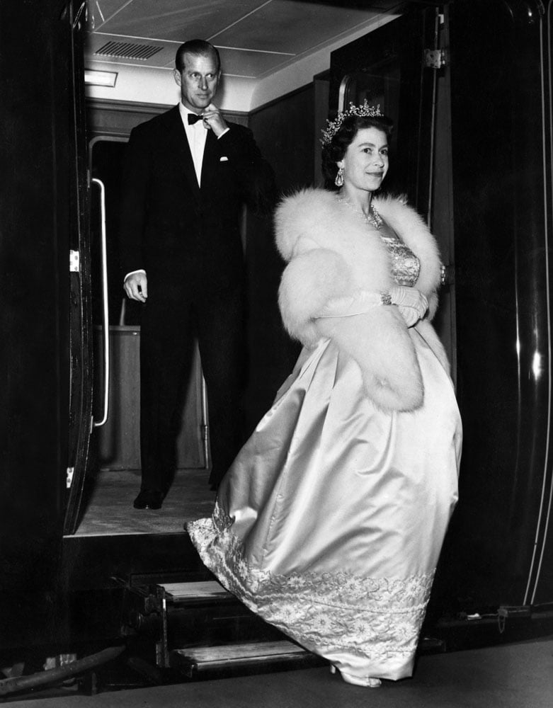 Her Majesty Queen Elizabeth II, followed closely behind by her husband Prince Philip, the Duke of Edinburgh, leaves the Royal train at Lime Street Station, Liverpool for an evening engagement at the start of their Lancashire tour. May 1961. - Source: Around Liverpool and Merseyside in the 1960's, iNostalgia Publishing / MirrorPix